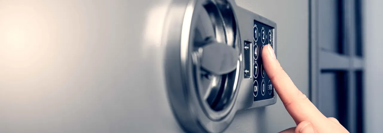 A hand entering a code on an electronic lock keypad